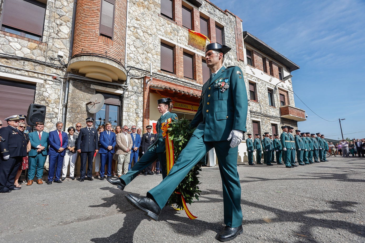 Dos guardias civiles desfilan en Torrelavega para realizar la ofrenda floral.