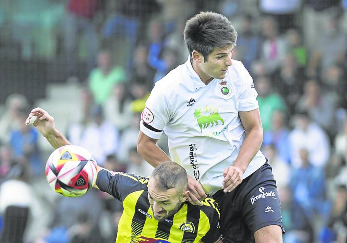 Cañizo, del Cayón, y Gomeza, del Rayo, en un salto para hacerse con el balón.