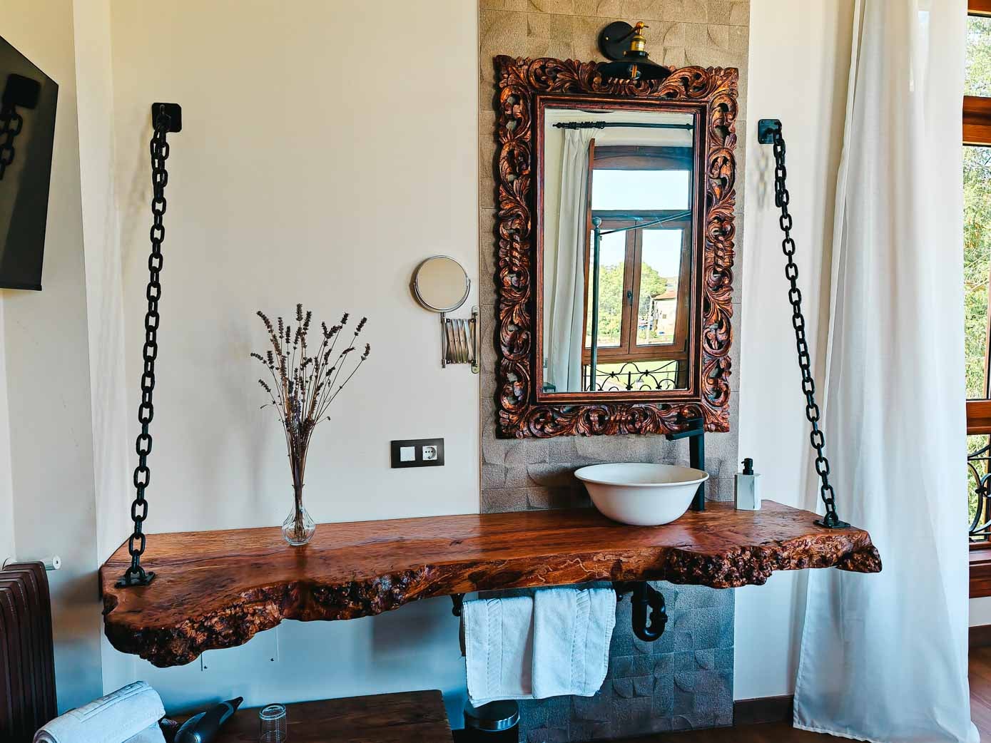 Lavabo hecho con un tronco de un árbol de nogal, de una sola pieza, sujeto con unas cadenas de hierro a la pared.