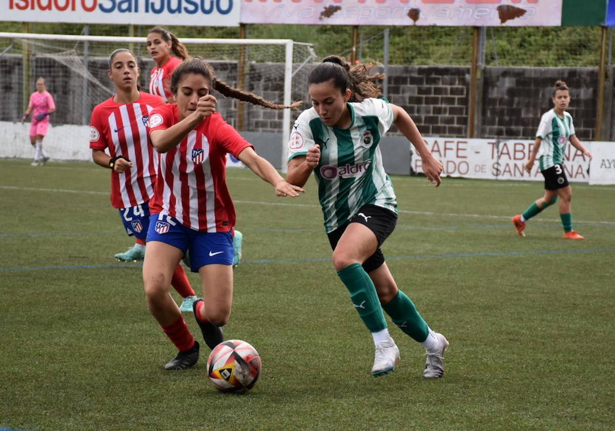 Irati, del Rayo Cantabria, trata de llegar al balón antes que una rival del Atlético de Madrid C