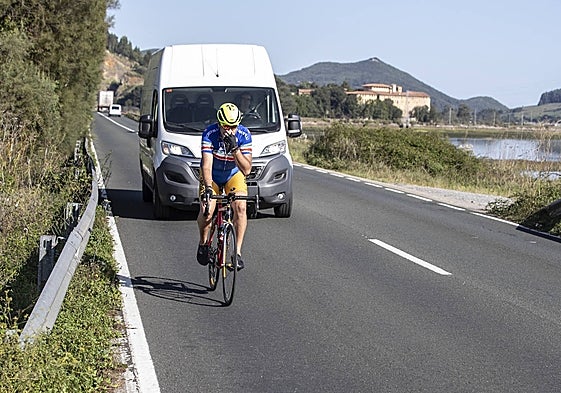 Una furgoneta circula detrás de un ciclista en la carretera de los puentes.