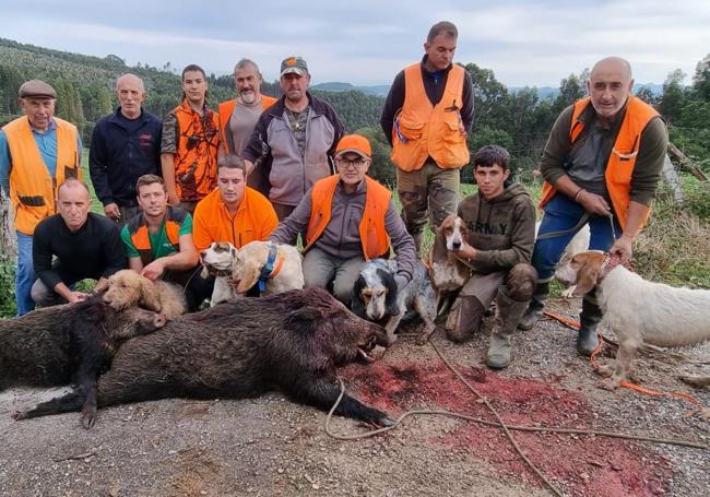 Socios del coto de Reocín, con dos jabalíes que mataron en el monte de Cerrazo en una reciente cacería.