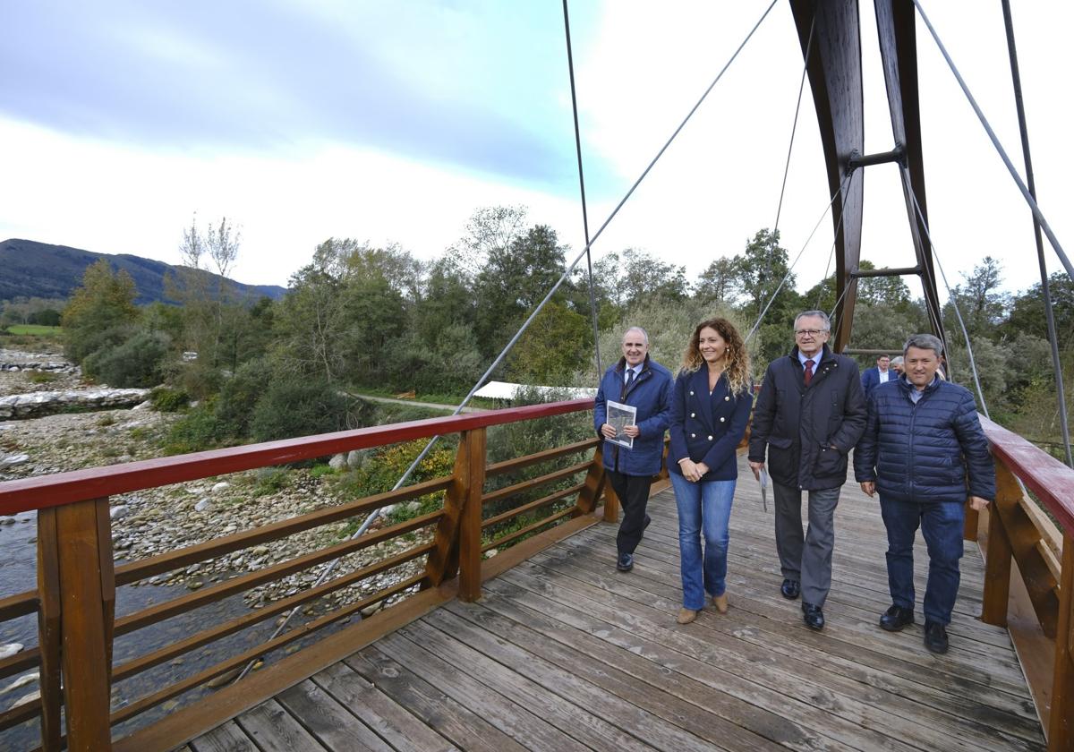 El director general, la delegada del Gobierno, el presidente de la CHC y el alcalde de Cabezón atraviesan la pasarela sobre el río.