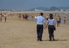 Dos auxiliares de Policía vigilando en la playa de Somo.