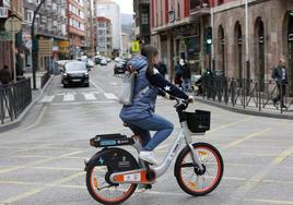 Una joven cruza Cuatro Caminos con una bicicleta eléctrica de Torrebici.