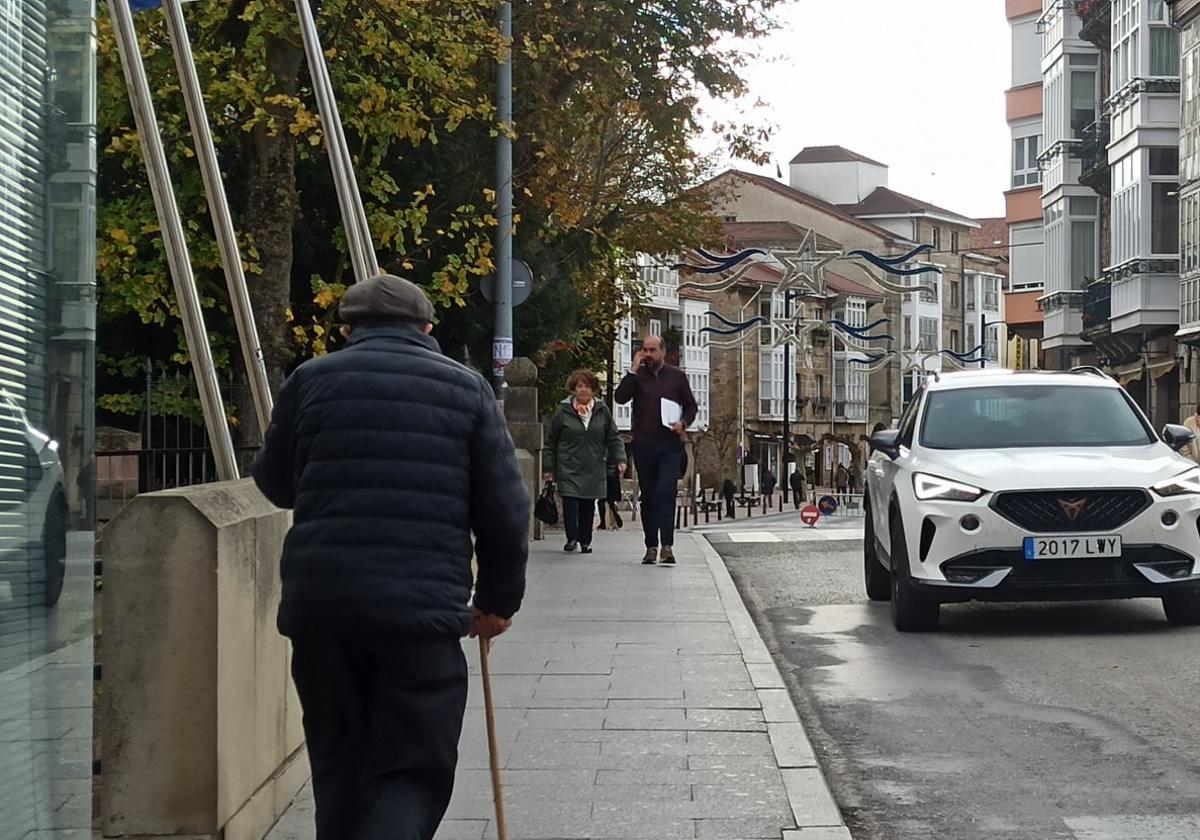 Ciudadanos paseando por una calle principal y comercial de Reinosa, en la avenida del Puente Carlos III.