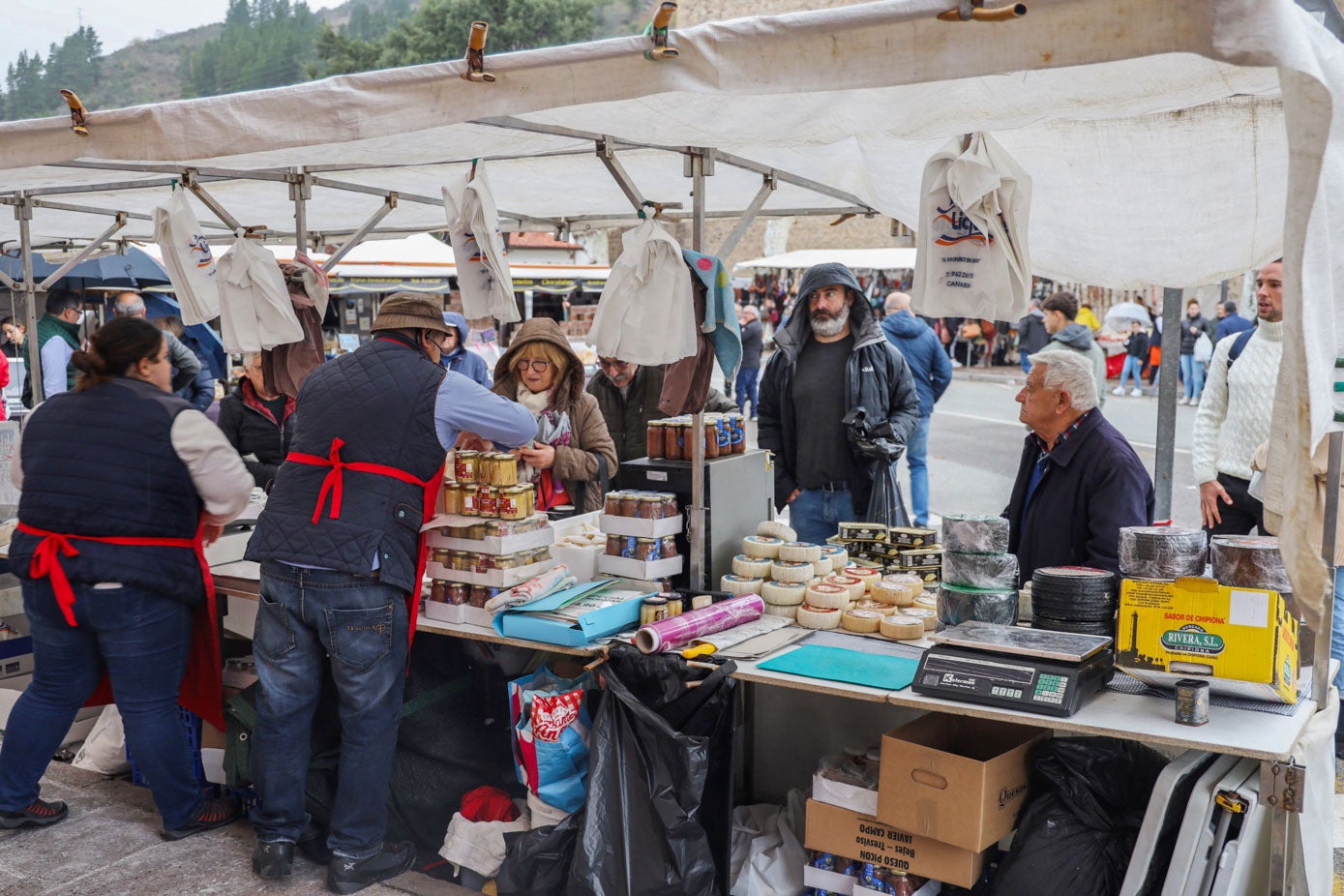 Varios clientes compran en un puesto de comida del mercado.