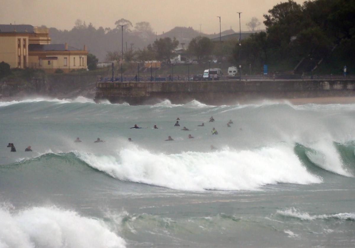 Varias personas hacen fotografías de las olas en El Sardinero