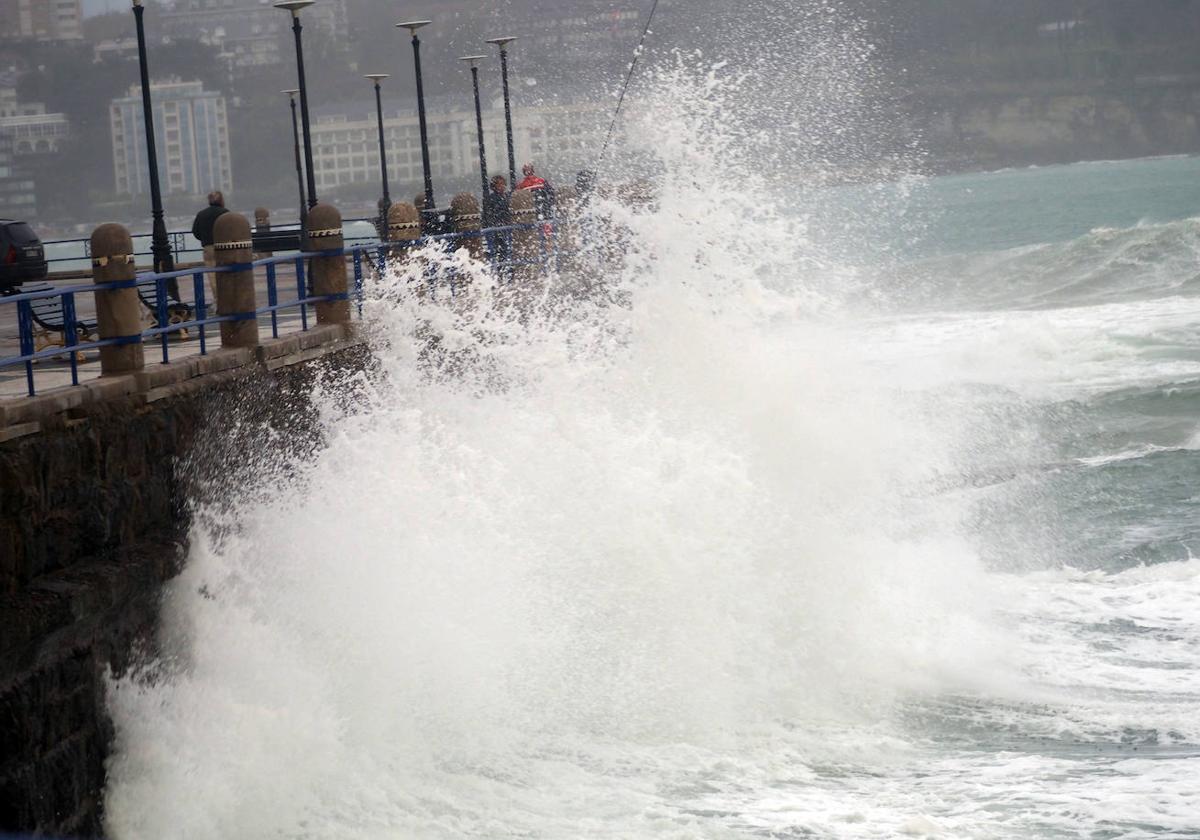 Una ola rompiendo contra el muro de la playa de El Camello.