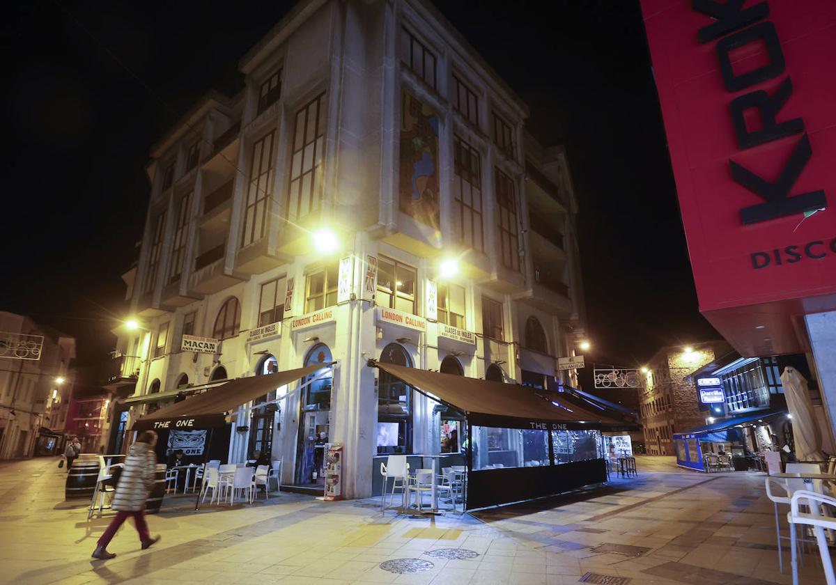 Una vecina camina por la zona de vinos de Torrelavega, el corazón de la fiesta y el ocio nocturno en la ciudad.