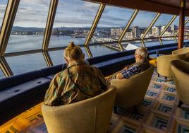 Dos pasajeros disfrutan de las vistas de la bahía desde el barco de lujo.