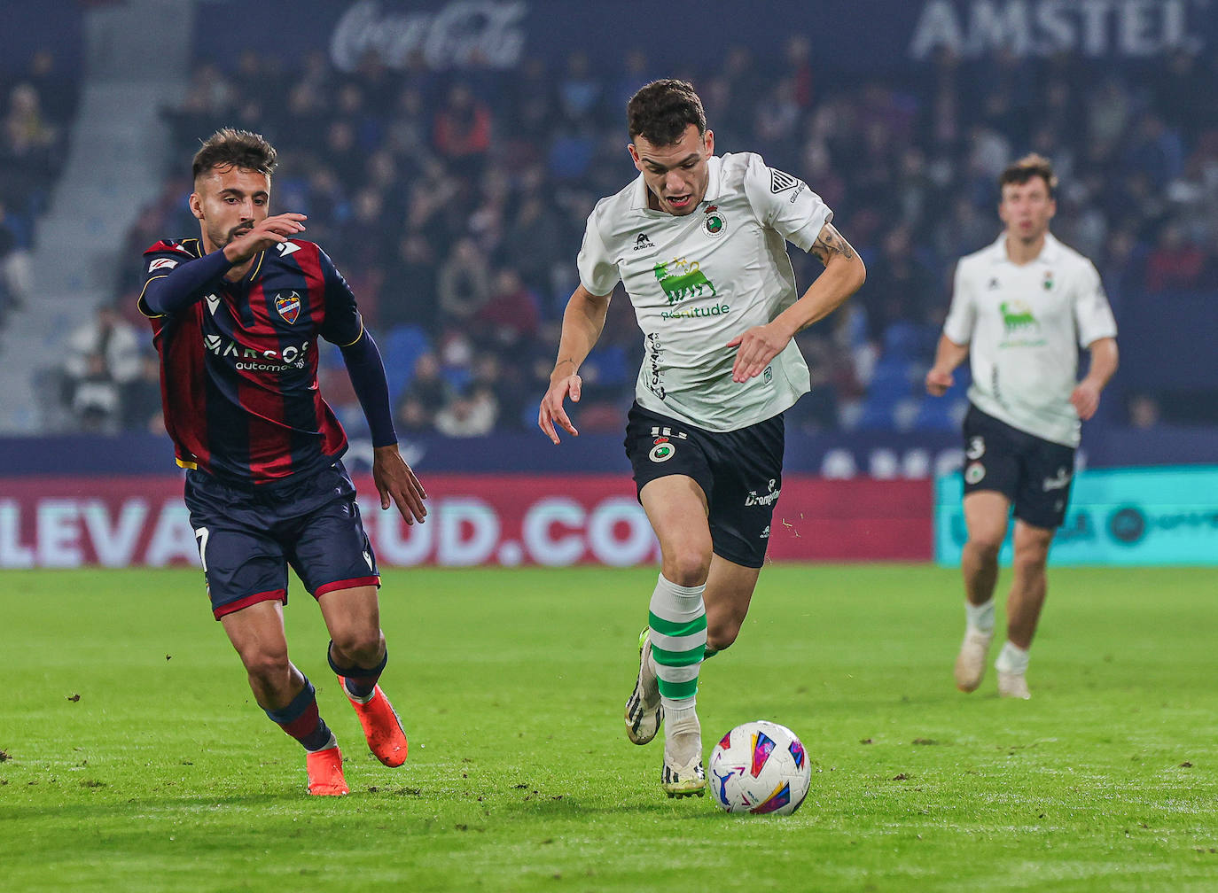 Íñigo Vicente, en carrera mientras un rival del Levante lo persigue. 