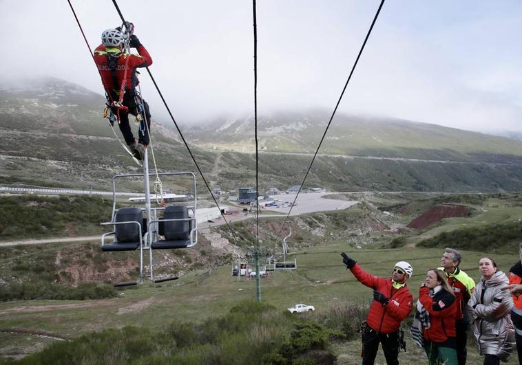 Uno de los rescatadores avanza por los cables del telesilla y otro explica a la consejera Isabel Urrutia, al director de Cantur Luis Martínez y a la directora de la estación, Cristina López en que consiste el ejercicio.