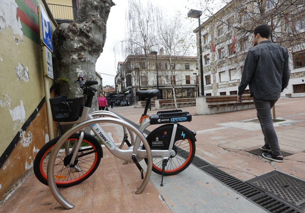 Un vecino camina junto a una zona de estacionamiento de las bicicletas, en la plaza Baldomero Iglesias de Torrelavega.