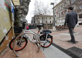 Un vecino camina junto a una zona de estacionamiento de las bicicletas, en la plaza Baldomero Iglesias de Torrelavega.