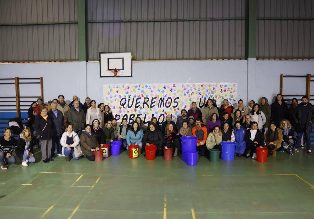 Medio centenar de padres y madres de alumnos del colegio Marqués de Estella, en Peñacastillo, posan junto a la pancarta que reclama un pabellón digno