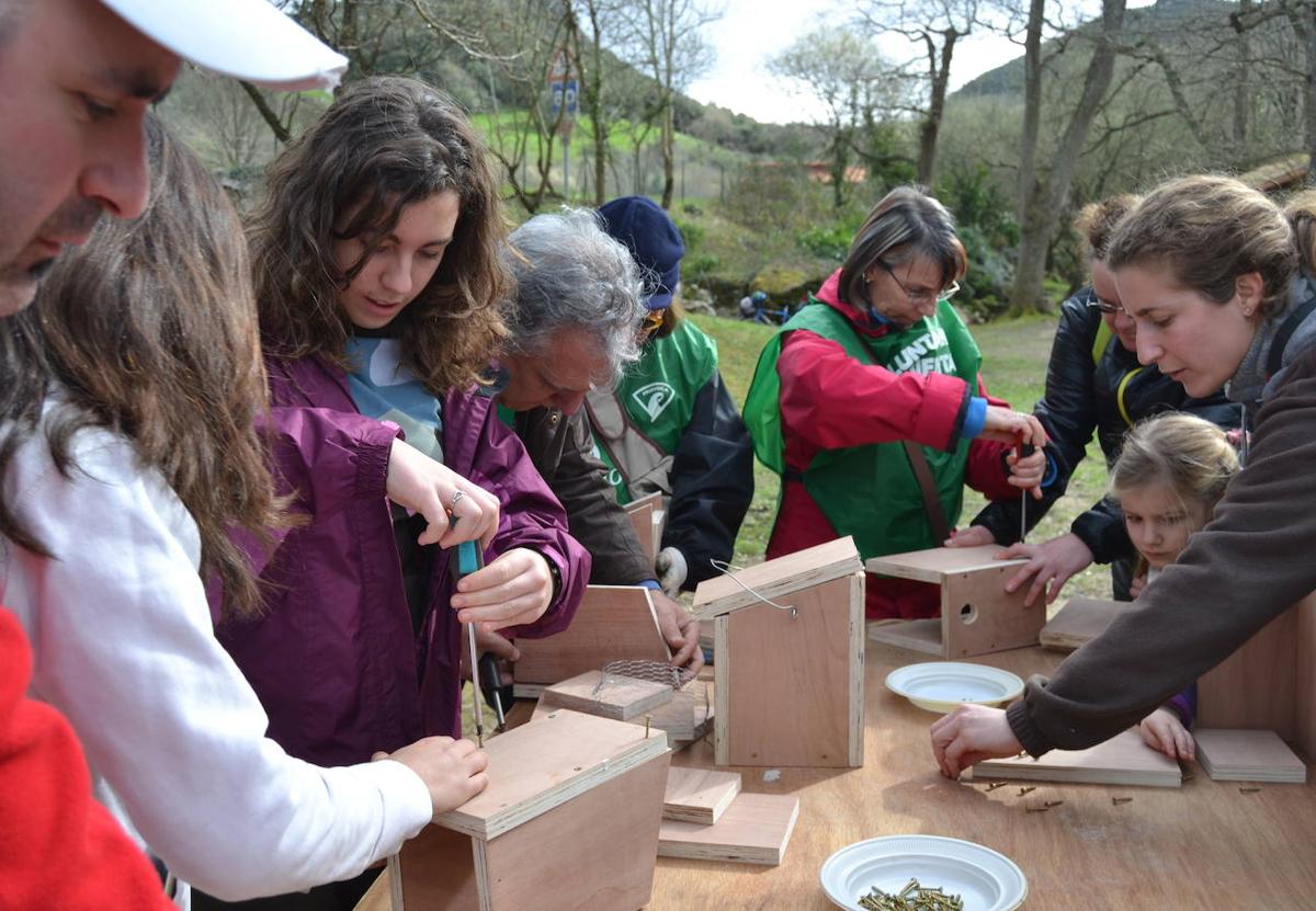 Voluntarios de la asociación Bosques de Cantabria en el Arboreto de Liendo, donde los monitores han enseñado a los participantes a construir casa-nido para los pájaros.