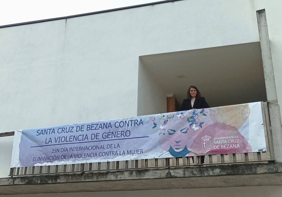 La alcaldesa de Bezana, Carmen Pérez, en el balcón del Ayuntamiento junto a la pancarta que condena la violencia de género.