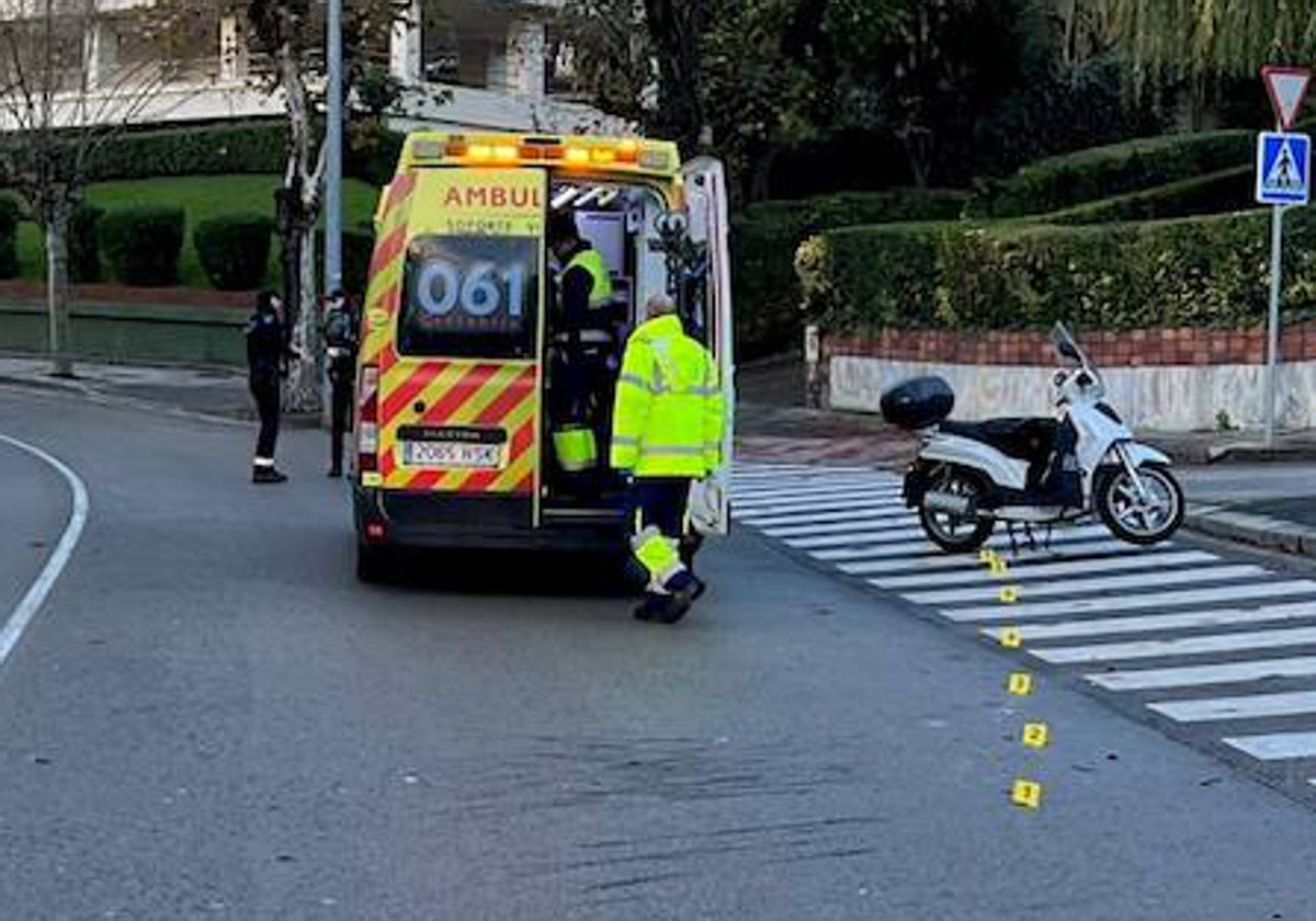 Los sanitarios atienden a la mujer herida en el lugar del accidente, donde se observa la motocicleta en la que viajaba.