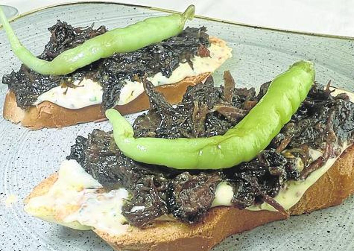 Imagen secundaria 1 - A la izquierda, tosta de brioche con carrillera sobre salsa tártara. A la derecha, rollito de cecina relleno de gorgonzola. 