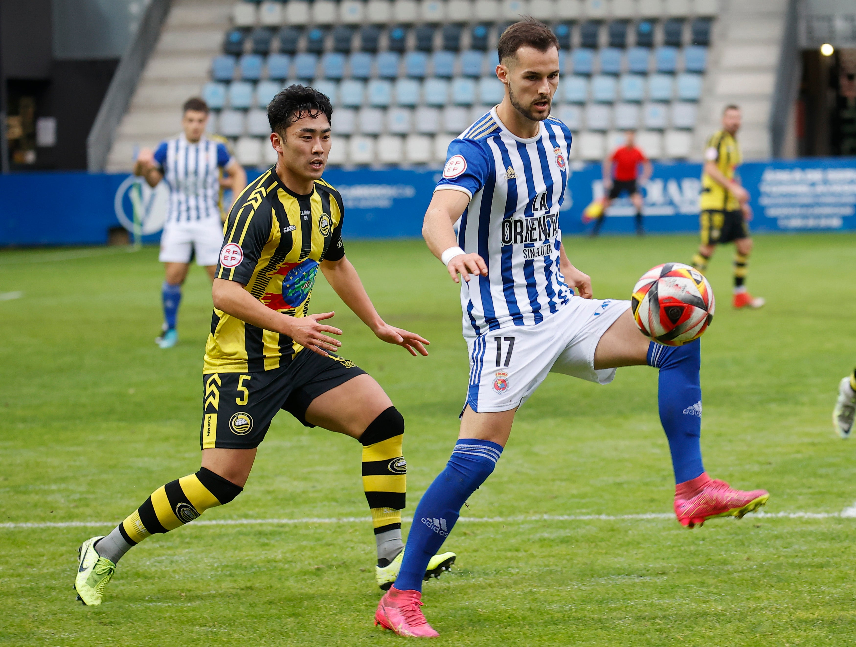 Delgado, de la Gimnástica, controla el balón ante Hitoshi.