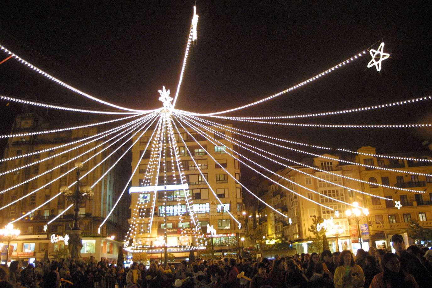 Árbol de Navidad e iluminación sobre la muchedumbre en la Plaza del Ayuntamiento de Santander.