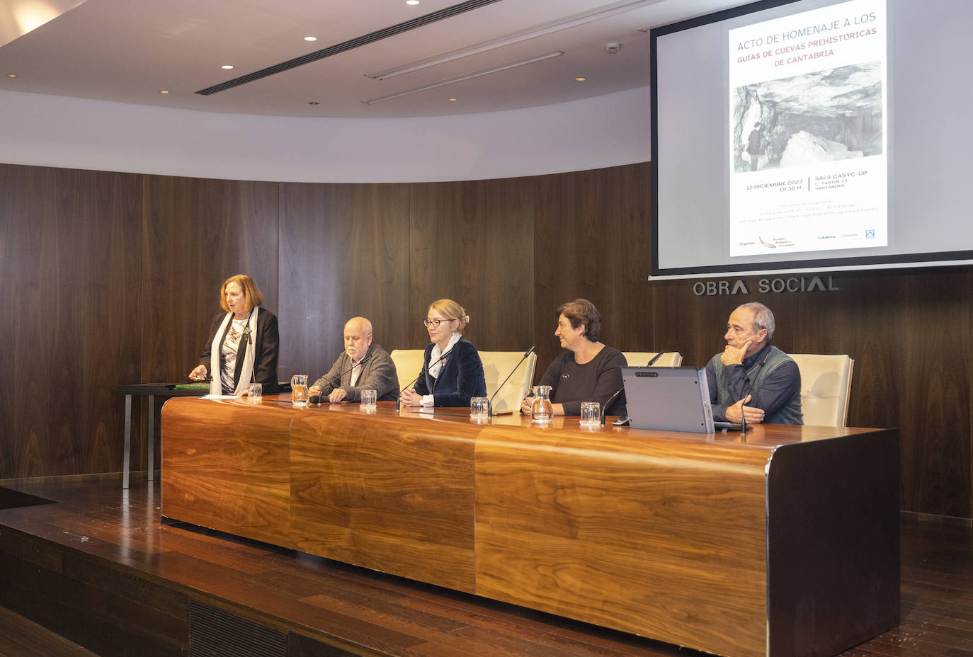 A la izquierda, la presidenta de la Sociedad Prehistórica de Cantabria, Ramona Fuente. Sentados, el catedrático de Prehistoria de la Universidad de Cantabria Manuel R. González Morales; la consejera de Cultura, Turismo y Deporte, Eva Guillermina Fernández; la directora del Museo Nacional y Centro de Investigación Altamira, Pilar Fatás; y el artista Juan Martínez Moro que, además de ser el autor del grabado que se entregó a los homenajeados, es es miembro de la junta directiva de la Sociedad Prehistórica.