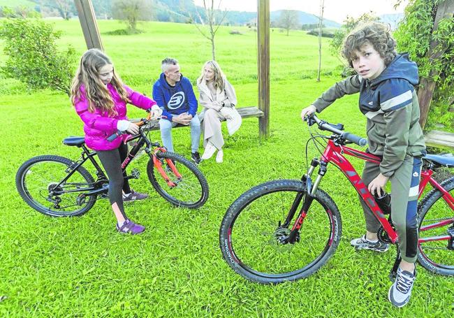 Hugo y Daniela juegan con sus bicis en presencia de sus padres, Eva y Eduardo.