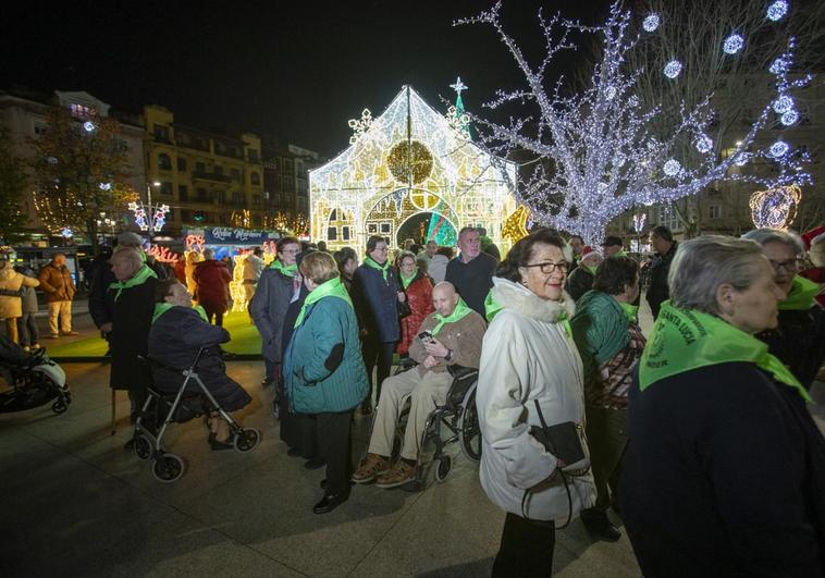 Personas mayores de dos residencias de Santander, ayer, disfrutan de las luces de la Plaza del Ayuntamiento.