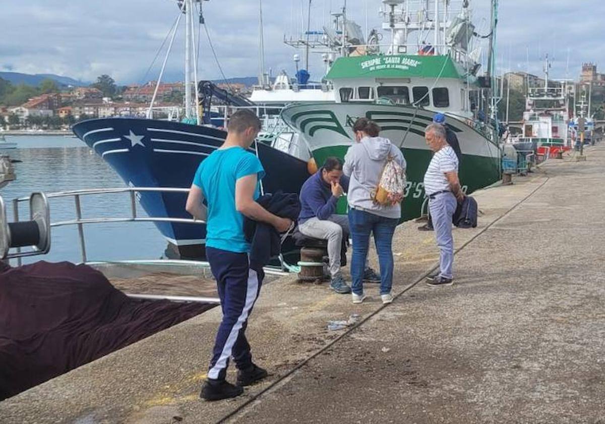 El patrón del Novo Xoel, abatido, en el puerto de San Vicente, acompañado por su esposa y otros miembros de la tripulación tras conocer el trágico suceso.