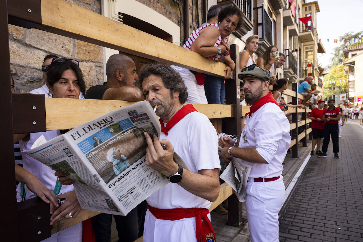 Los encierros de Ampuero dejaban está completa imagen, homenaje a nuestros lectores. Pegados a las vallas, listos para correr, los apuerenses comprueban en las páginas de El Diario Montañés cada detalle de los encierros del día anterior.