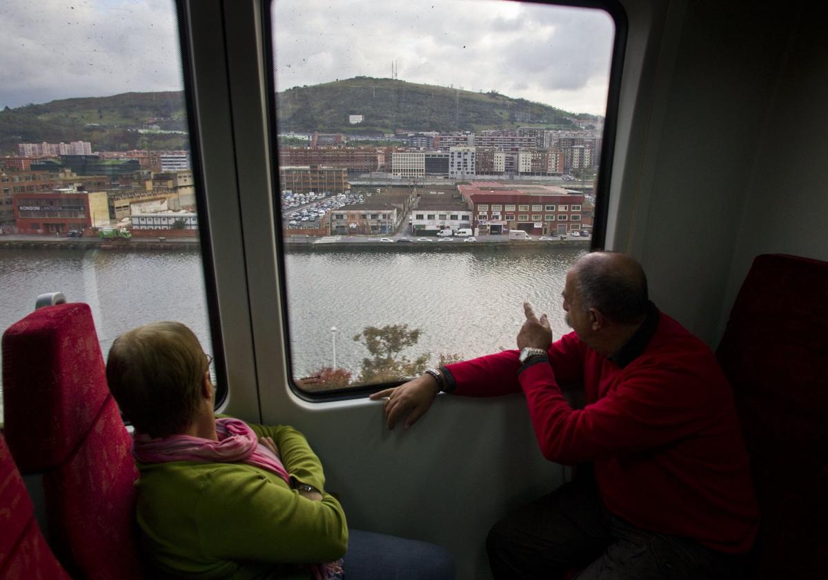 Dos pasajeros de un tren en el trayecto de Santander a Bilbao a su llegada a la capital vizcaína.