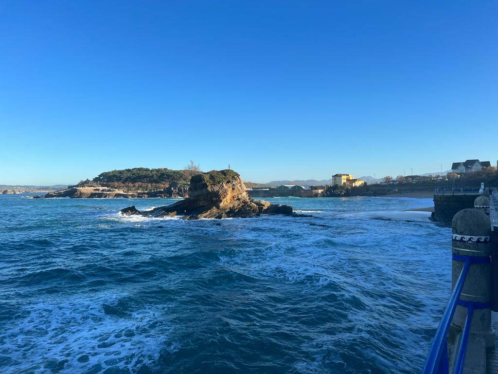 Llegamos a la playa del Camello, que recibe su nombre por la singular forma de una de sus rocas, que dependiendo del nivel de la marea se puede observar en mayor o menor medida. Allí está la figura que que popularmente se conoce como 'Niño pez', un homenaje a la infancia y también un símbolo de la ciudad. Al fondo se observa el Palacio de la Magdalena.