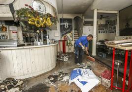 Un operario recoge el escombro y adecenta el local del Urbano's una semana después del incendio que afectó a esta cafetería de la calle Mártires de Torrelavega.