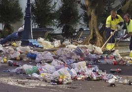 Operarios de limpieza de Santander recogen basura el 1 de enero de 2023, en la plaza de Pombo.