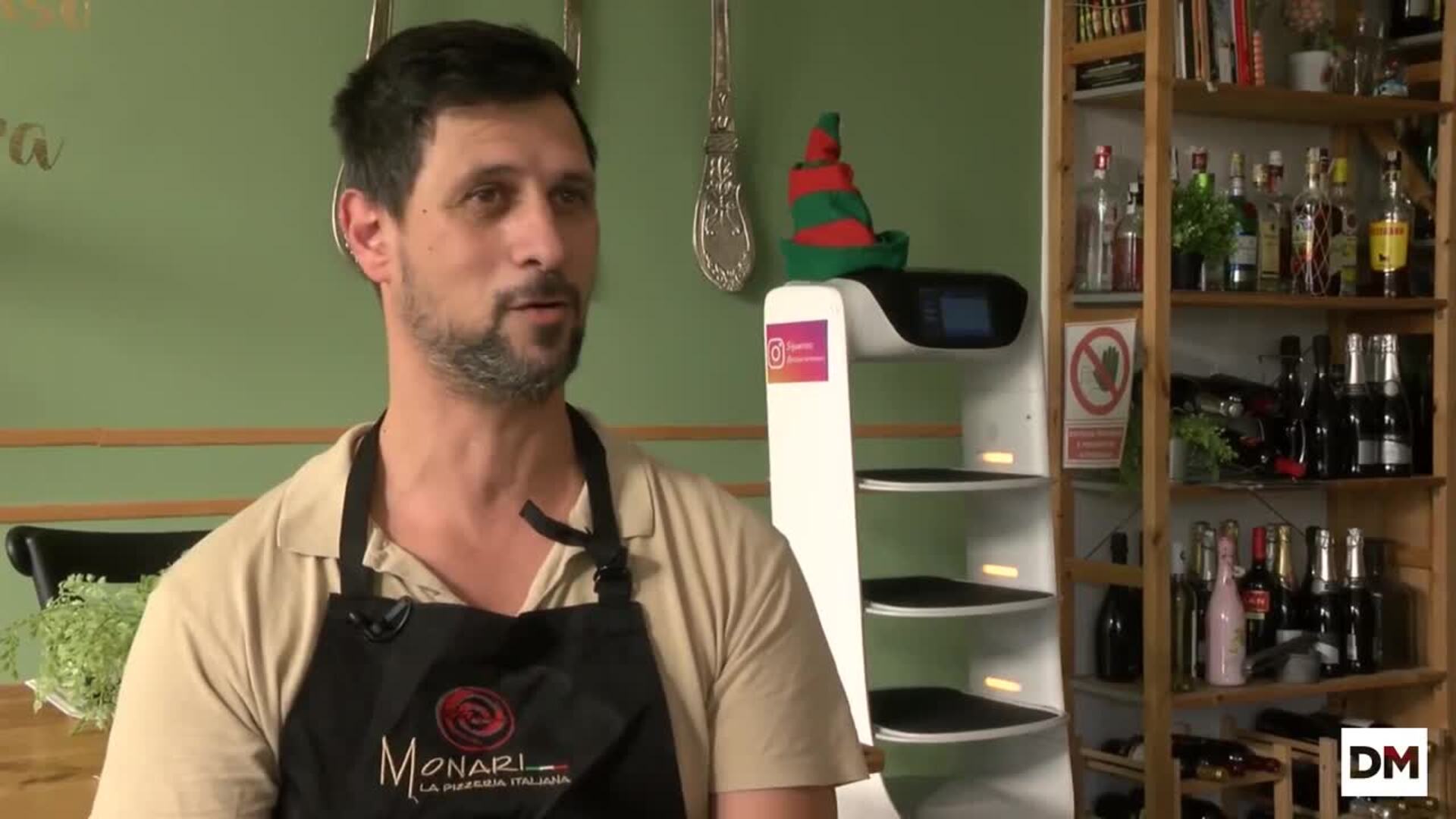 Dos empleados y un robot en la pizzería Monari