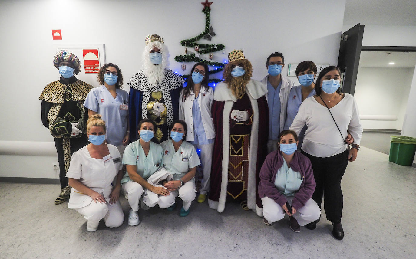 Los tres Reyes Magos, acompañados por los sanitarios de Pediatría de Valdecilla, junto a la voluntaria de Buscando Sonrisas, Marta Sánchez, de pie, a la derecha.