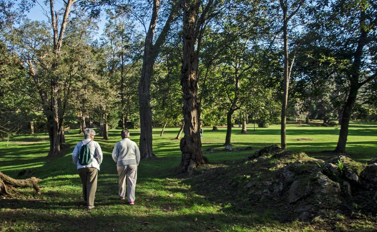Dos mujeres pasean por el acceso central del Parque de Rosequillo. 