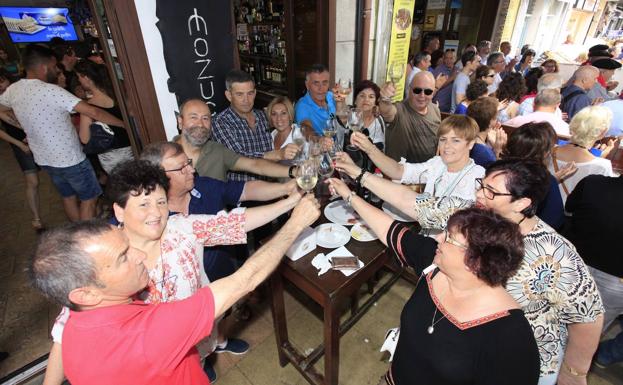 Un grupo de amigos brindan en el centro de la villa.