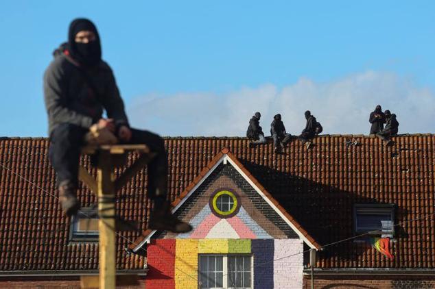 Los activistas se han encaramado a estructuras de madera y tejados de viviendas ocupadas para dificultar su desalojo.