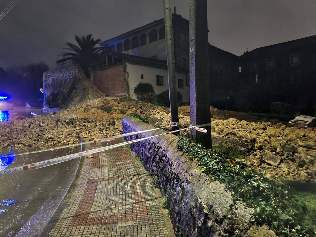 Otro lateral de los efectos del muro desplomado, con la zona acordonada por la policía.