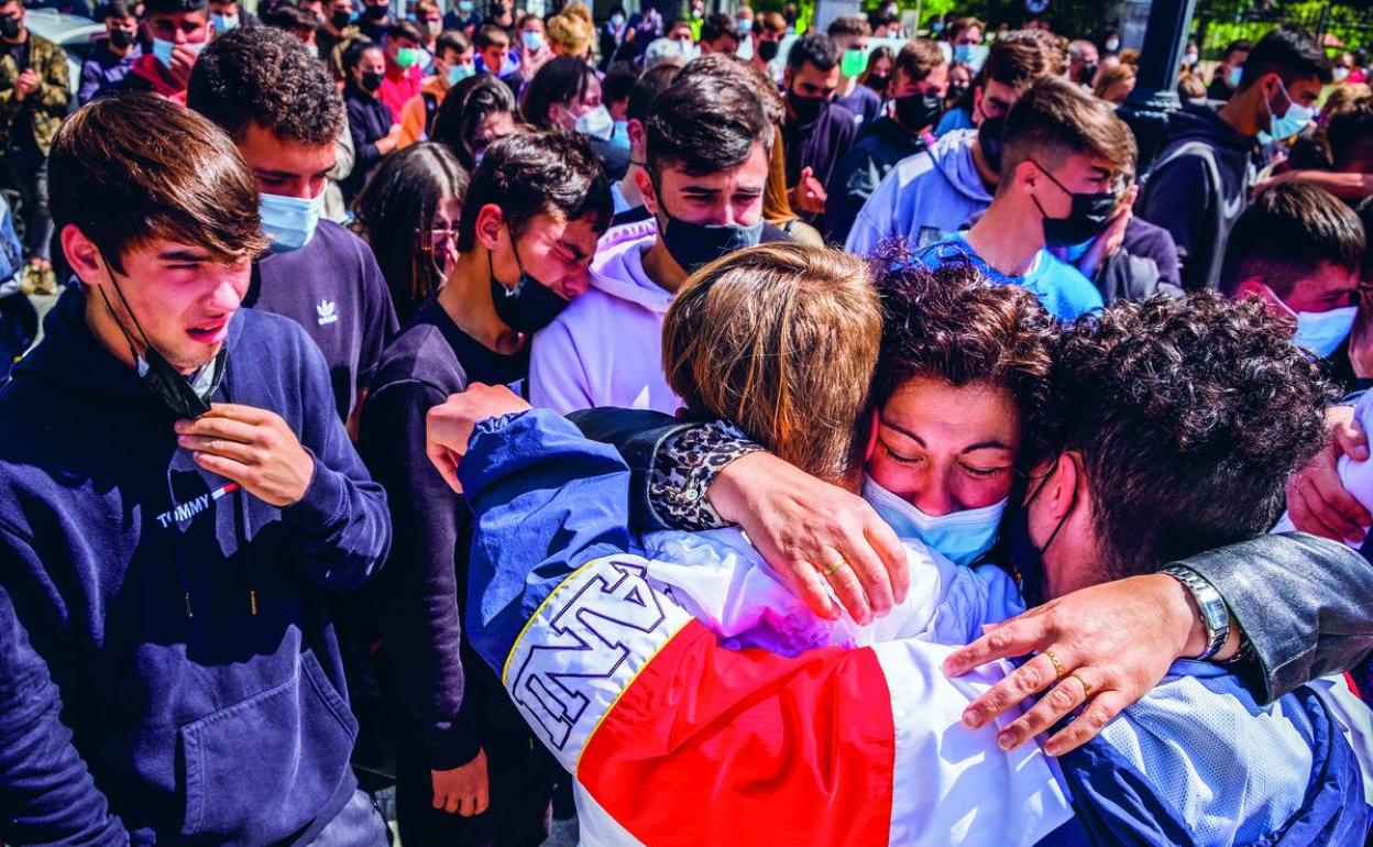 Maylo, la madre de Mario Fuentes, recibe el abrazo de los amigos de su hijo días después del crimen. 