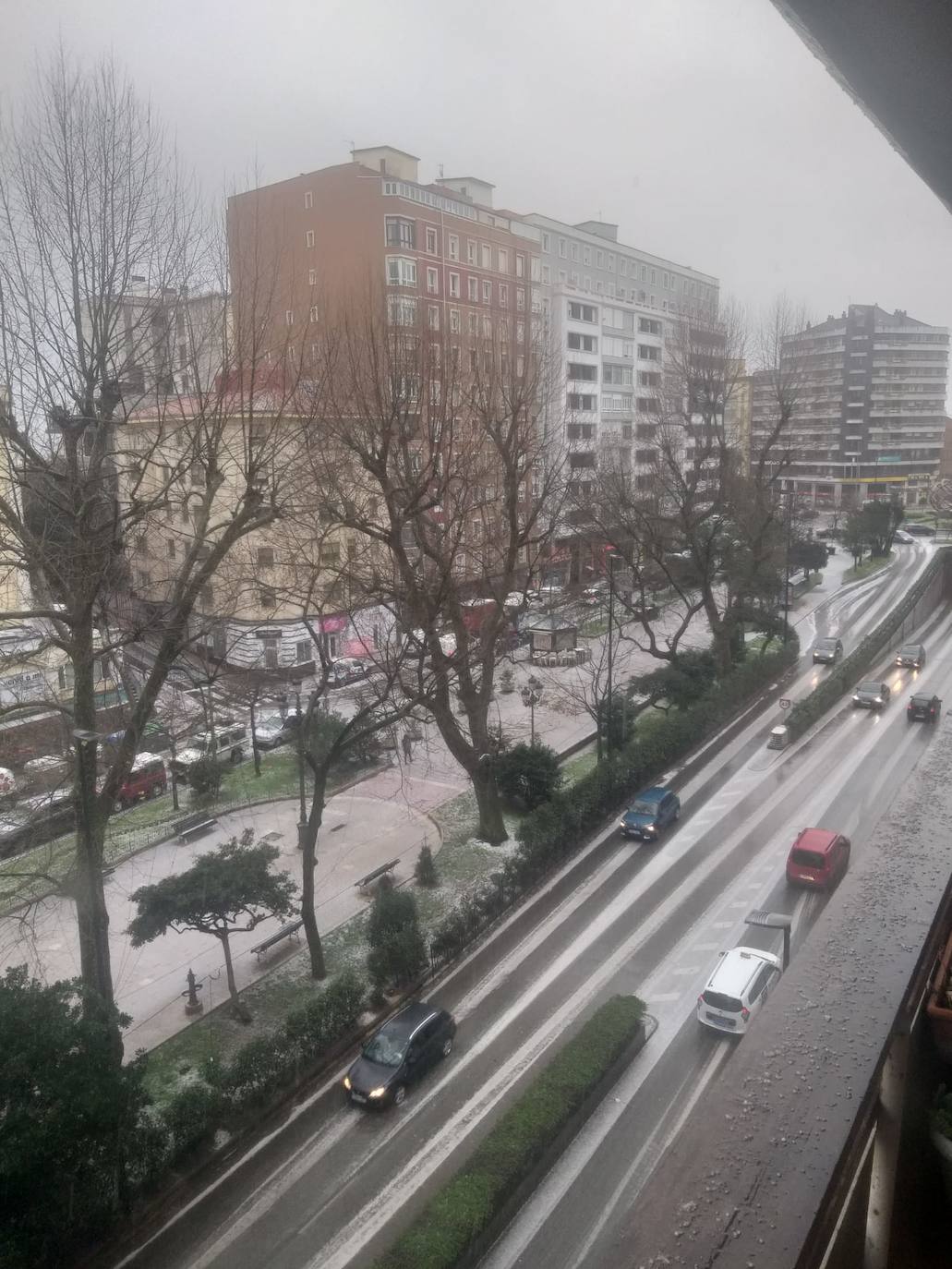 En Santander a falta de nieve, este miércoles las granizadas también tiñen las calles de blanco. Esta foto fue tomada pasadas las doce de la mañana en la calle San Fernando.