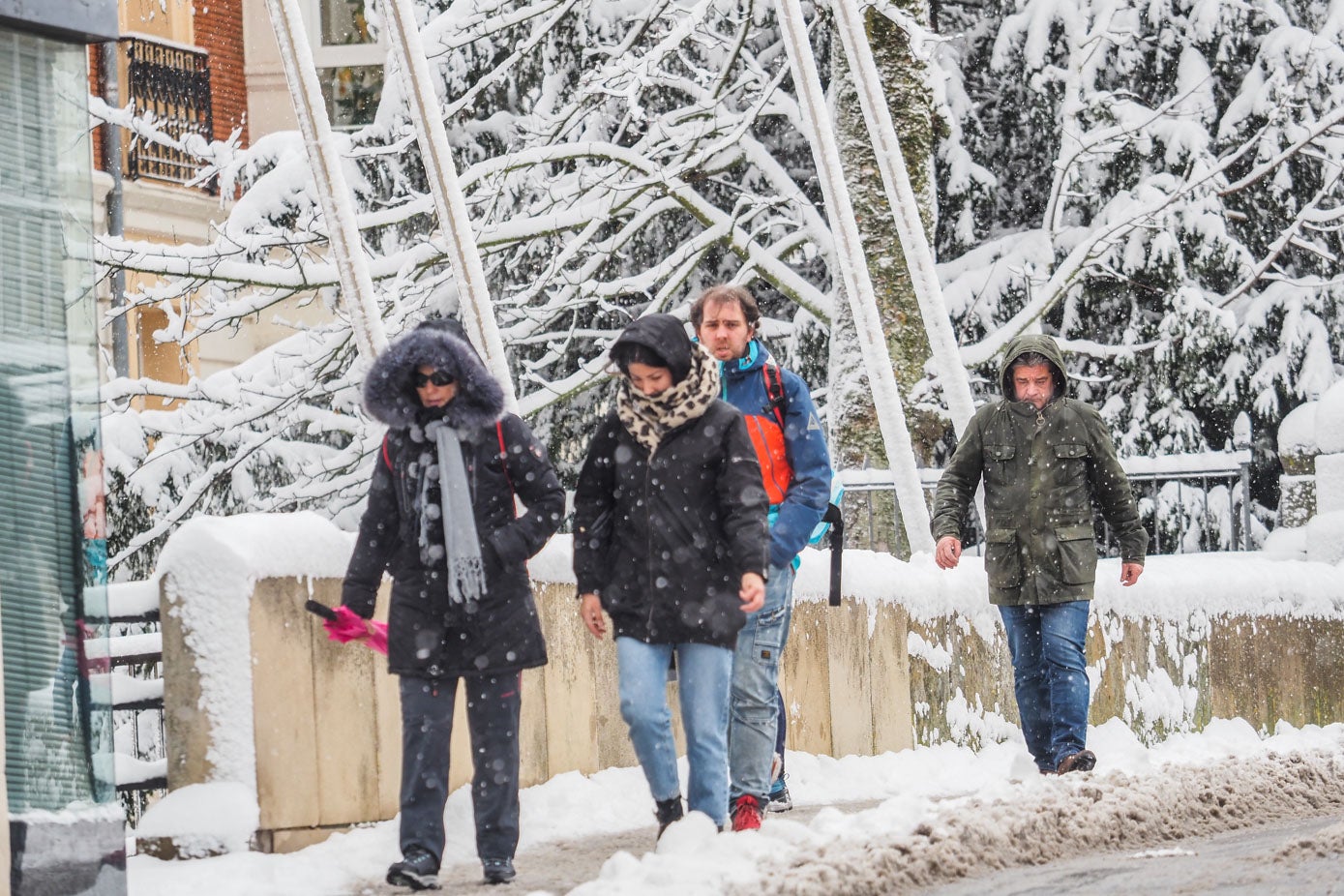 Reinosanos, muy abrigados, caminando por la ciudad campurriana bajo la nieve.