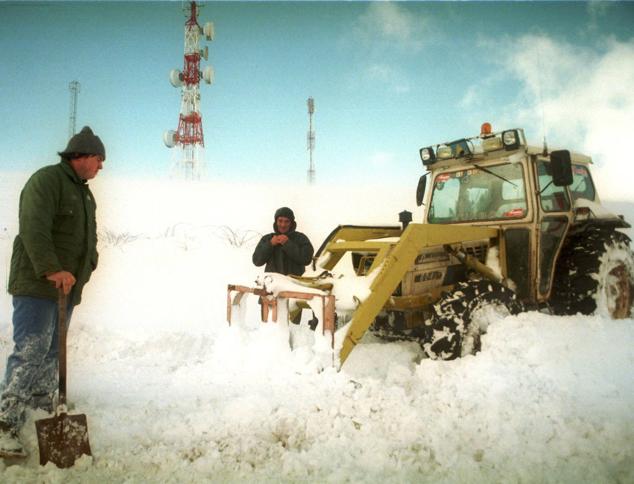 Quienes están acostumbrados a ver nevar no se sorprenden con poco. Los ganaderos de las zonas altas de la región se las apañan cada invierno para llegar hasta las cabañas donde se encuentran sus animales. Precisamente en esta imagen, tomada en el año 2001, se ve a dos de ellos tratando de despejar la carretera con un tractor y una pala en Luena. 