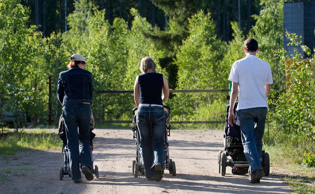 Padres paseando a sus hijos pequeños.