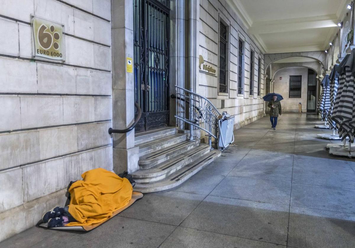 Una persona sin hogar duerme en los soportales de la Plaza Porticada.