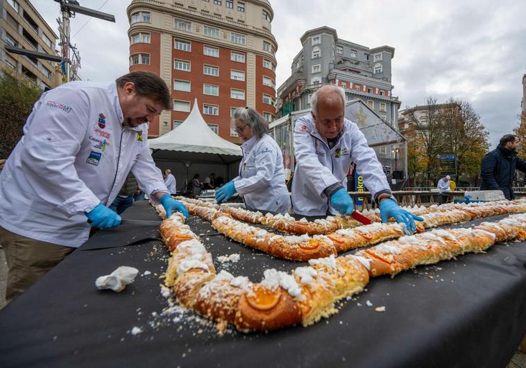 Tres cocineros racionan los 144 roscones de Reyes que repartirán entre el público.