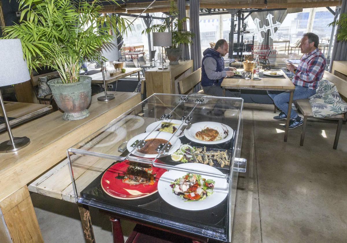 Un expositor muestra a los clientes los platos que integran el menú del día en este restaurante.