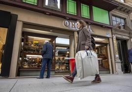 Una mujer camina con las bolsas de regalos por la calle Lealtad, de Santander.